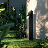 Two Strata Pro powder-coated aluminum pathway lights in a planted bed in daylight, showing the slim body and angled head
