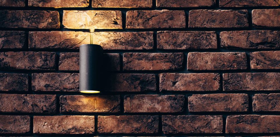 solar flood light fixture mounting on brick wall with screw holes