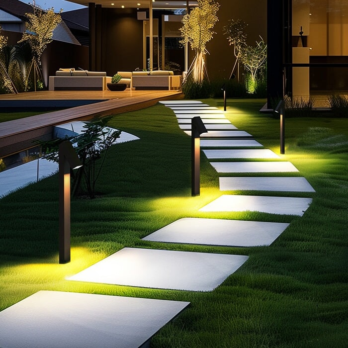Strata Pro solar pathway lights lining a stepping stone walkway across a lawn at night, warm 3000K light pooling on each paver